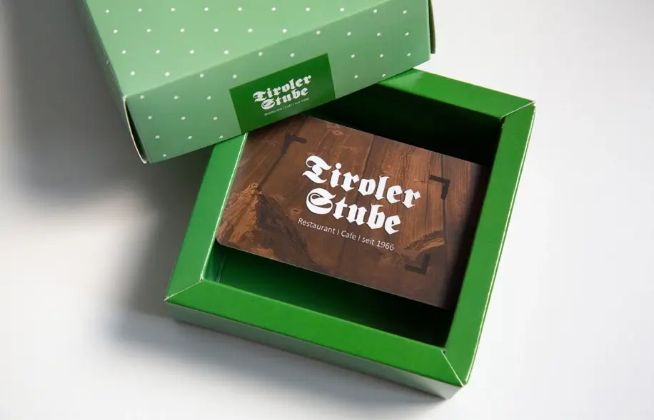 Geöffnete Geschenksverpackung mit der Scheckkarte als Gutschein.